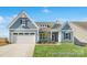 Charming craftsman-style home featuring a spacious two-car garage and manicured front yard at 1303 Links Crossing Dr # 219, Monroe, NC 28112