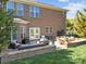 Brick back exterior featuring a cozy patio with lounge furniture and an outdoor dining area for entertaining at 135 Northbridge Dr, Mooresville, NC 28115