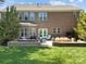 Back exterior showcases a brick facade, large windows, and a patio with outdoor seating and a dining area at 135 Northbridge Dr, Mooresville, NC 28115
