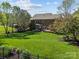 Spacious backyard featuring a well-manicured lawn, a brick patio, and mature trees surrounding the property at 135 Northbridge Dr, Mooresville, NC 28115