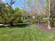 Well-maintained backyard with lush green grass, mature trees, and a black wrought iron fence, creating a private outdoor space at 135 Northbridge Dr, Mooresville, NC 28115