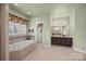 Bathroom showcasing a tiled tub, dark wood cabinets, and neutral decor at 135 Northbridge Dr, Mooresville, NC 28115