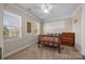 Well-lit bedroom featuring a wooden bed frame, carpet floors, and multiple windows at 135 Northbridge Dr, Mooresville, NC 28115