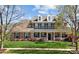 Charming brick home featuring a covered front porch, dormer windows, shutters, and manicured landscaping at 135 Northbridge Dr, Mooresville, NC 28115
