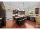 Eat-in kitchen with breakfast bar, dark cabinetry, updated appliances, and wood floors; perfect for cooking at 135 Northbridge Dr, Mooresville, NC 28115