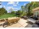 An inviting patio with outdoor furniture, including a dining table, lounge chairs, and views of the lush lawn at 135 Northbridge Dr, Mooresville, NC 28115