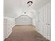 Finished attic space featuring neutral carpeting, built-in drawers, and ample lighting, creating a versatile room at 1413 Willow Oaks Trl, Weddington, NC 28104