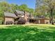 Picturesque view of a brick home with a manicured lawn and mature trees providing ample shade and privacy at 1413 Willow Oaks Trl, Weddington, NC 28104