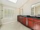 Elegant bathroom featuring double vanities with dark granite countertops and a skylight for natural illumination at 1413 Willow Oaks Trl, Weddington, NC 28104