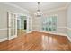 Dining room with hardwood floors, chandelier, and shuttered windows at 1413 Willow Oaks Trl, Weddington, NC 28104