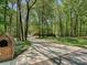 Long driveway leading to a traditional brick home, surrounded by mature trees at 1413 Willow Oaks Trl, Weddington, NC 28104