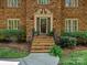 Elegant entryway with brick steps, black railing, and decorative plants at 1413 Willow Oaks Trl, Weddington, NC 28104