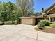 Spacious garage with an extended driveway, complemented by meticulous landscaping and lush greenery at 1413 Willow Oaks Trl, Weddington, NC 28104