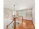 Well-lit hallway with hardwood floors and built-in bookshelves, adding charm and functionality to the space at 1413 Willow Oaks Trl, Weddington, NC 28104