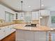 Bright kitchen with white cabinets, granite countertops, and a center island with a gas cooktop at 1413 Willow Oaks Trl, Weddington, NC 28104