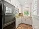 Kitchen featuring white cabinets, stone countertops, and stainless-steel appliances, creating a modern cooking space at 1413 Willow Oaks Trl, Weddington, NC 28104