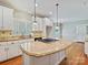 Bright kitchen featuring white cabinets, light granite countertops, wood floors and stainless gas cooktop at 1413 Willow Oaks Trl, Weddington, NC 28104
