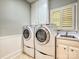 Convenient laundry room featuring a sink, storage and a window with natural light at 1413 Willow Oaks Trl, Weddington, NC 28104