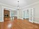 Open living room with fireplace, hardwood floors, and french doors at 1413 Willow Oaks Trl, Weddington, NC 28104