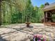 Private stone patio with a central fountain and picturesque views of the wooded backyard at 1413 Willow Oaks Trl, Weddington, NC 28104