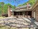 Expansive brick patio with fountain, screened porch, and mature landscaping, creating a serene outdoor living space at 1413 Willow Oaks Trl, Weddington, NC 28104