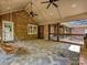 This screened in porch has a stone floor and rustic swing at 1413 Willow Oaks Trl, Weddington, NC 28104