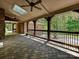 Charming outdoor porch featuring brick pavers, wood beams, ceiling fans, and views of the surrounding landscape at 1413 Willow Oaks Trl, Weddington, NC 28104