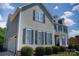 This attractive two-story home boasts gray siding, black shutters, a two car garage, and well maintained landscaping at 143 S Gibbs Rd, Mooresville, NC 28117
