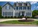 Attractive two-story home with gray siding, black shutters, manicured landscaping, and circular fountain in the front yard at 143 S Gibbs Rd, Mooresville, NC 28117