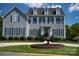 Traditional two-story home with gray siding, black shutters, manicured landscaping, and a circular fountain in the front yard at 143 S Gibbs Rd, Mooresville, NC 28117