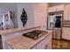 Kitchen island featuring a gas cooktop and granite countertops adjacent to stainless steel refrigerator at 143 S Gibbs Rd, Mooresville, NC 28117