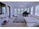 Elegant living room showcasing a piano, stylish chandelier, and abundant natural light through multiple windows at 143 S Gibbs Rd, Mooresville, NC 28117
