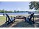Scenic waterfront view with Adirondack chairs around a fire pit, and a private dock on the lake at 143 S Gibbs Rd, Mooresville, NC 28117