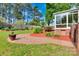 Serene backyard showcasing a brick patio, lush greenery, and manicured landscaping at 1473 12Th Street Nw Dr, Hickory, NC 28601