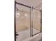 Bathroom showcasing a bathtub with a clear glass enclosure, tiled walls, and decorative wallpaper at 1473 12Th Street Nw Dr, Hickory, NC 28601