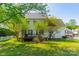 Spacious backyard featuring a deck, lush lawn, mature trees, and partial picket fence, perfect for outdoor activities and relaxation at 16718 Hampton Crossing Dr, Huntersville, NC 28078