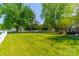 Expansive backyard with a sprawling green lawn, mature trees, and partial deck view, perfect for recreation and relaxation at 16718 Hampton Crossing Dr, Huntersville, NC 28078