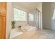 Bright bathroom featuring a soaking tub beneath a large window and a glass-enclosed shower stall at 16718 Hampton Crossing Dr, Huntersville, NC 28078
