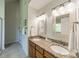 Bathroom with double sink vanity, granite countertop, framed mirrors, stylish lighting, and a door to a shower/toilet room at 16718 Hampton Crossing Dr, Huntersville, NC 28078