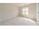Empty bedroom with neutral carpet, two windows, and base molding at 16718 Hampton Crossing Dr, Huntersville, NC 28078