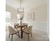 Bright dining room featuring a round table, neutral chairs, and carpet, illuminated by a modern chandelier at 16718 Hampton Crossing Dr, Huntersville, NC 28078