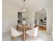 Cozy dining area with a round table and upholstered chairs, next to open doorway revealing hardwood floors beyond at 16718 Hampton Crossing Dr, Huntersville, NC 28078