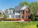 Charming two-story home with a combination of white siding and brick, complemented by a lush, landscaped front yard at 16718 Hampton Crossing Dr, Huntersville, NC 28078