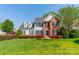 Beautiful two-story home with a well-maintained lawn, featuring a mix of siding and brick with black shutters at 16718 Hampton Crossing Dr, Huntersville, NC 28078