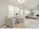 Bright seating area with large windows and furniture, seamlessly flowing into the living room at 16718 Hampton Crossing Dr, Huntersville, NC 28078