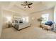 Spacious main bedroom features a tray ceiling, neutral decor, ceiling fan, and large windows allowing lots of natural light at 16718 Hampton Crossing Dr, Huntersville, NC 28078