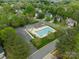 Aerial view of a community pool with a lounge area, set amid mature trees and manicured lawns, perfect for relaxation at 16718 Hampton Crossing Dr, Huntersville, NC 28078