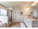 Bright primary bathroom with a walk-in shower, a soaking tub, and and vanities at 17712 Yarwill Ct, Charlotte, NC 28278