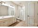 A bright bathroom featuring a double vanity, tile floors, a large mirror, and a walk-in shower at 17712 Yarwill Ct, Charlotte, NC 28278
