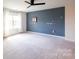 A spacious bedroom with a large window and blue accent wall, illuminated by soft, natural light at 17712 Yarwill Ct, Charlotte, NC 28278